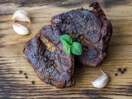 Delicious lamb steaks roast baked with mint garlic marinade displayed on wooden cutting board with fresh mint leaves. Horizontal, top view, middle eastern recipeの写真素材