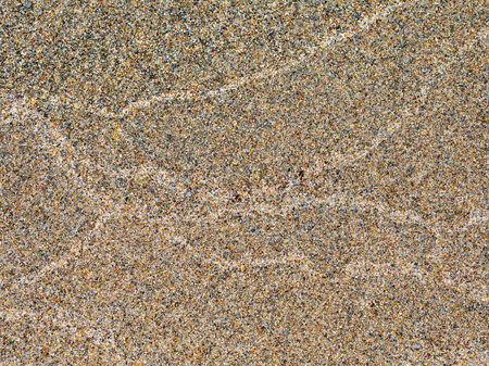 The texture of the sea waves on wet sand.の写真素材