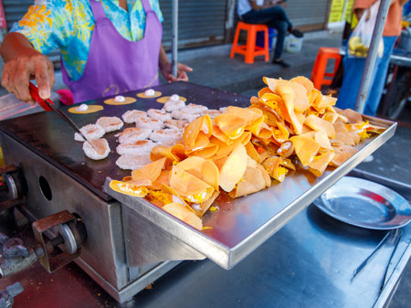 Woman cooking Khanom Buang Thai or a kind of filled pancake Thai food or Thai Style small Crispy Tart on local market tray, Thailand.の写真素材