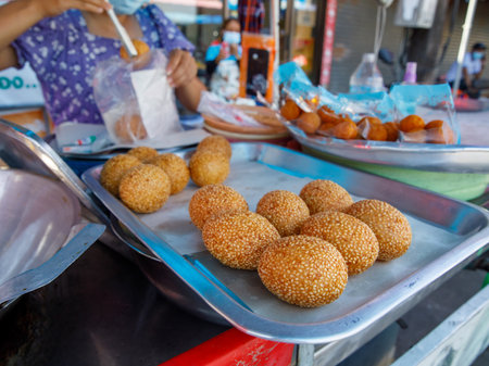 Khanom Kai Hong with sesame or Swan Eggs Dessert, native Thailand fried dessert balls like doughnuts on local marketの写真素材