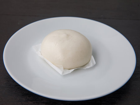 Salapao dim Sum China and thailand traditional street food, stuffed steamed bun on white plate on...