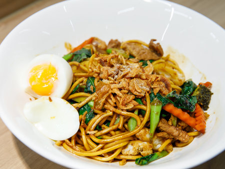 Stir fried yellow noodle Mee pad hokkian phuket, rice yellow noodle with soy sauce, pork, vegetables and egg. thai food phuketの写真素材