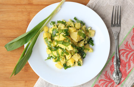 easy vitamin potato salad with Wild leek in white plate on linen and wooden tableの写真素材