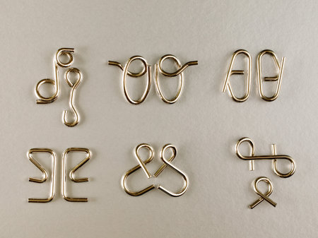The various metal wire puzzle (puzzle ring) on gray background. Top view flat lay. brain teaser.の写真素材