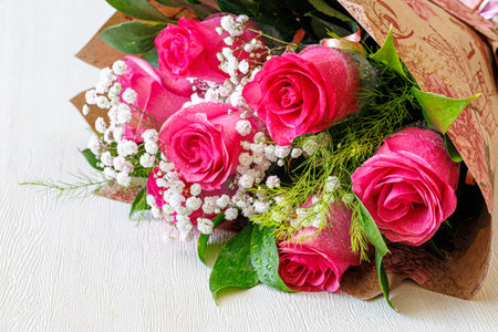 Bouquet of Pink Roses and Gypsophila on white Wooden Backgroundの写真素材