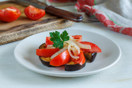Healthy Salad with fresh and grilled vegetables. Vegetable salad with fried eggplant and fresh tomato and onion on plate. Healthy vegetarian foodの写真素材