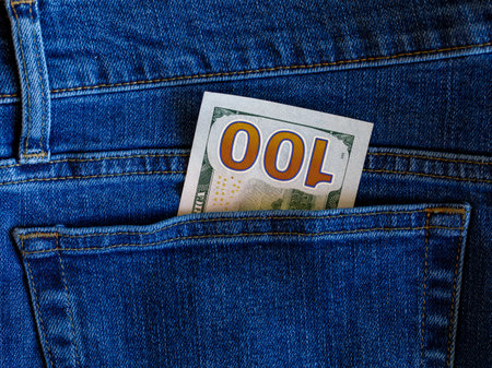 One hundred dollar banknote money in back pocket jeans pants background texture. 100 dollar bill close up Money, business, finance, saving, banking, wealth, waste concept. Exchange Rates.の写真素材