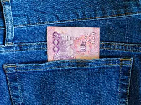 Close up banknote 500 bath thai in blue jeans back pocket top view with copy space.. concept saving, investment, stock market and transfer money. Exchange Rates.の写真素材
