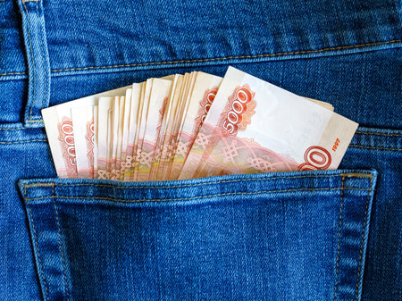many 5000 Russian rubles banknotes, money in the back pocket of blue jeans. Concept of salary, savings, pocket money, investments, income, money, business, finance, banking, wealth. Exchange Rates.の写真素材