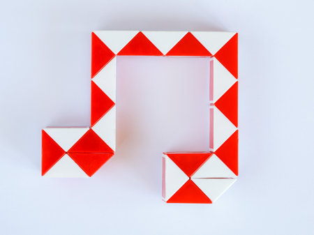 red and white bicolor magic snake Transformable twist puzzle in shape of music notes isolated on white background. it develops spatial thinking.の写真素材