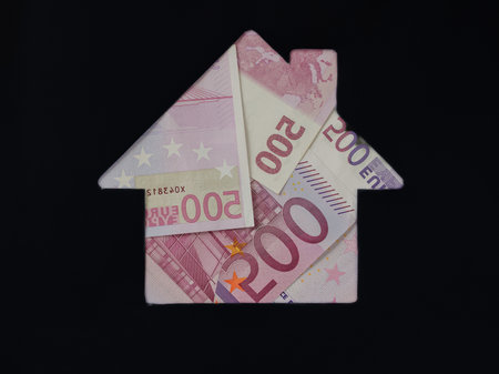 Euro banknote in shape of house on black background. Concept of Investment property, Mortgage concept. Investment risk and uncertainty in real estate housing market, utility bills. Top view flat lay.の写真素材