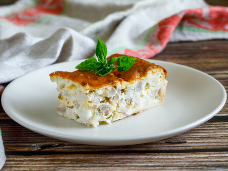 Piece of a chicken meat and cheese pie on plate, close upの写真素材