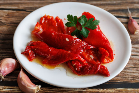 Peeled peppers, salad from grill baked marinated vegetable pepper, grilled fresh, portion on plate, ready to eat meal snack on the table, close up, food background, rusticの写真素材