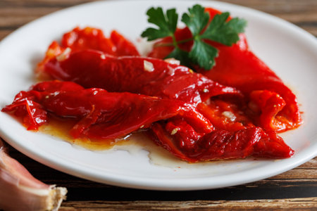 Peeled peppers, salad from grill baked marinated vegetable pepper, grilled fresh, portion on plate, ready to eat meal snack on the table, close up, food background, rusticの写真素材