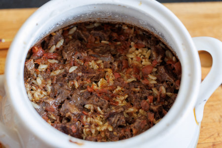 Giouvetsi - traditional Greek and Cretan baked dish with beef and orzo pasta in tomato sauce in baking pot, top viewの写真素材