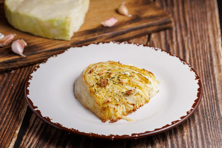 Homemade grilled cabbage steaks. Healthy vegetarian food ready to eat on a serving plate, cutlery. Wooden table background, close upの写真素材