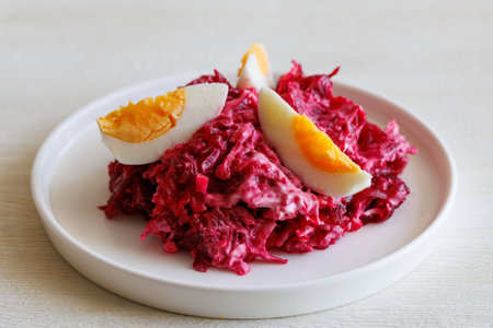 Beetroot salad with mayonnaise with cheese and egg on white background.の写真素材