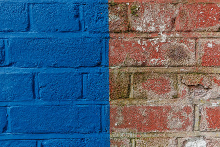 Old urban weathered brick wall half painted with blue paint . Bicolor abstract background, close upの写真素材