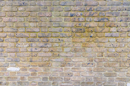 Beige grunge weathered brick wall, abstract full frame background texture with old dirty and vintage style patternの写真素材