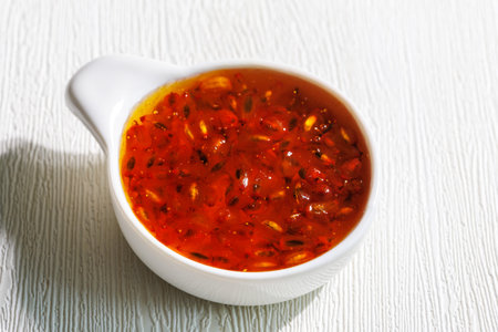 Delicious homemade sea buckthorn jam with whole berries in ceramic bowl on white table, closeupの写真素材