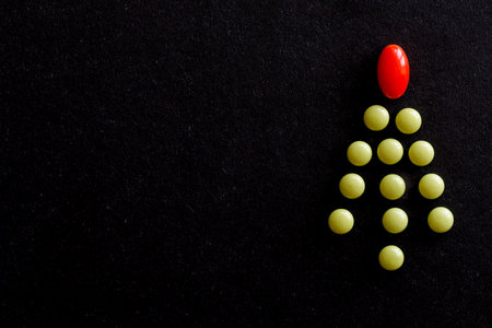 Round green tablet in shape of Christmas tree with red star on black background. Unusual tree. Copy spaceの写真素材