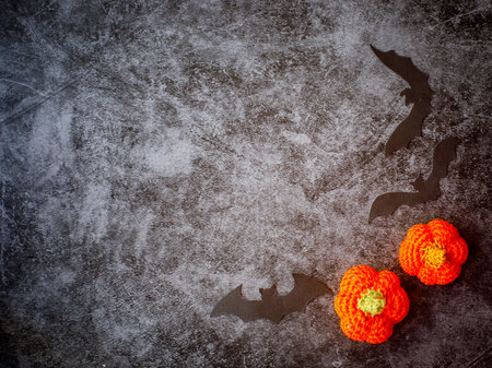 not closed Border Frame of two crocheted orange pumpkin with three black bat silhouettes on grey marble backgroundの写真素材