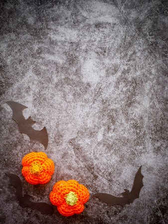 not closed Border Frame of two crocheted orange pumpkin with three black bat silhouettes on grey marble backgroundの写真素材
