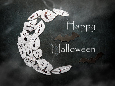 Happy Halloween Greeting , Some white ghosts in shape of moon and black bat with text Happy Halloween and fog on black background. Top viewの写真素材
