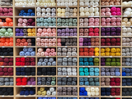 Shop shelf with multicolored yarn for knitting. Various color for creativity, crocheting and needlework. Bright colorful yarn balls full frame backgroundの写真素材
