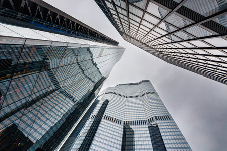 skyscraper buildings in business district, London City. Cloud day sky. Low angle view. Europe financial economy, merger and acquisition, or modern architecture concept, grey urban backgroundの写真素材