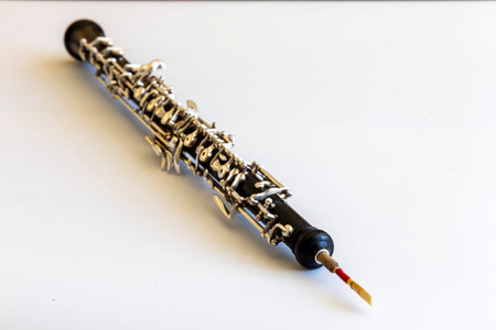 Oboe on white background, reed in foreground, body and keys are blurredの写真素材