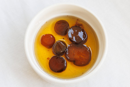 Traditional delicious Turkish dessert aubergine jam. Turkish name patlican receli. In white bowl isolated on white background. Close up, top view.の写真素材