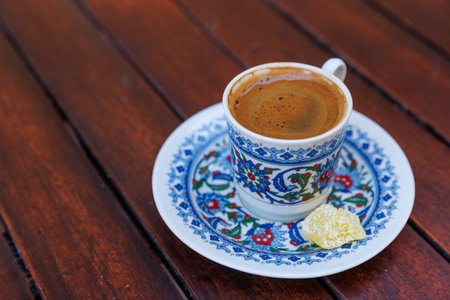 Traditional delicious Turkish coffee or Greek coffee with foam in ornate cup on wooden tableの写真素材