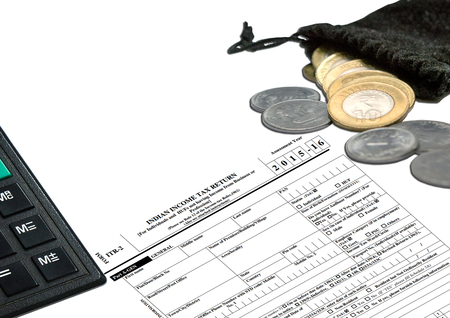 Tax Form ITR-2 with Indian Currency calculator and pen, with coins put inside the bagの写真素材