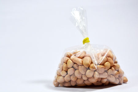 Raw Arachis hypogaea,peanut or groundnuts in a bag on isolated white background.の写真素材