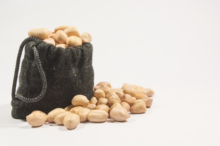 Peanuts in burlap bag isolated on white backgroundの写真素材