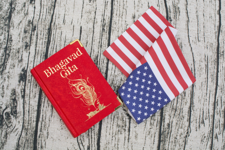 Maski,Karnataka,India - DECEMBER 29,2018 : Holy Bhagavad gita on America Flag with woden textured bckground.のeditorial素材