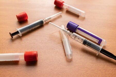 Plain Clot bloot Activators and syringe's on wooden textured table in Laboratory, India.の写真素材