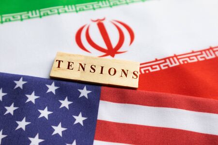 Concept of bilateral relations of US and Iran showing with flag and War with wooden block letters.の写真素材