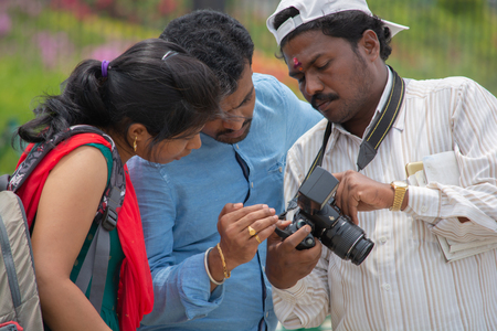 Bangalore, Karnataka India-June 04 2019 :Indian photographer showing photos to clients on photo camera screen, Couple looking at imageのeditorial素材
