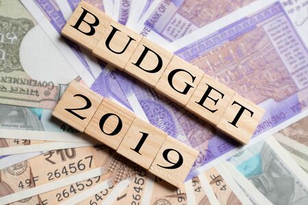 Budget 2019 printed on Wooden block letters with New Indian currency notes as a backgroundの写真素材