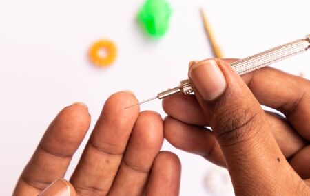 Sujok or acupressure therapy, inserting needle to the fingers with Sujok injector on isolated backgroud.の写真素材