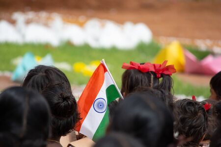School children sat ground by holding Indian flag in hand during Independence day of Indiaの写真素材