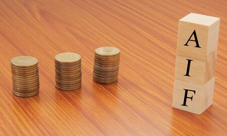 Alternative investment Funds or AIF on wooden block letters with Stack of currency coins