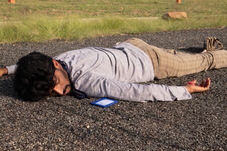Concept of Crime or murder scene , Closeup of victim dead body laying on Roadside.