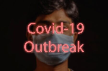 COVID-19 Novel coronavirus or 2019-nCoV, man with blue medical face mask on background and written Covid-19 Outbreak. Concept of coronavirus quarantine outbreak.の写真素材