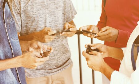 Young people busy in playing smartphone video games at college - group of friends busy on using...