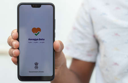 Maski, India-12, April 2020 : Hand holding aarogya setu app launched by government of India for self assesment from coronavirus or covid-19 outbreak.のeditorial素材