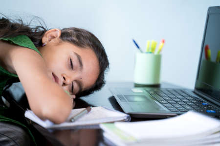 Bored Girl child slept infront of laptop - concept of kid tired from e-learning or online education at home during covid-19 or coronavirus outbreak.の写真素材