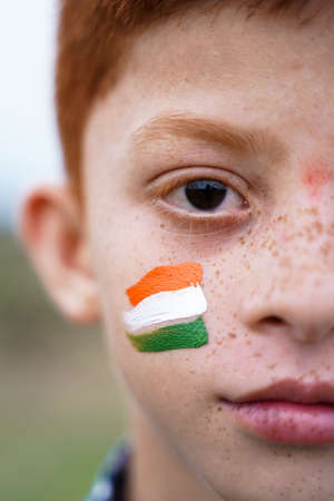 Closeup of Tricolor Indian flag Painted on Kid face during Indian Independence day - concept of patriotism or support for countryの写真素材